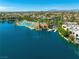 An aerial view of a lagoon style pool with palm trees, lounge chairs, docks and neighborhood at 2736 Huber Heights Dr, Las Vegas, NV 89128