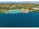Scenic aerial view of the sandy community pool, palm trees, lounge chairs, and neighborhood on the lake at 2736 Huber Heights Dr, Las Vegas, NV 89128