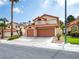Inviting two-story home featuring a two-car garage, desert landscaping, and tile roof, perfect for curb appeal at 2736 Huber Heights Dr, Las Vegas, NV 89128
