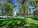 Lush green space with mature trees offers a serene setting near the water, perfect for relaxation and recreation at 2736 Huber Heights Dr, Las Vegas, NV 89128
