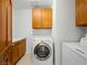 A convenient laundry room featuring cabinetry, countertops, and a stacked washer and dryer at 2736 Huber Heights Dr, Las Vegas, NV 89128