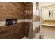 Bathroom showcasing a tiled shower with shampoo niche and decorative wood paneling at 2822 La Palma Dr, Laughlin, NV 89029
