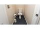 Compact bathroom featuring a white toilet and stylish blue-gray tile flooring at 2822 La Palma Dr, Laughlin, NV 89029
