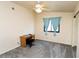 Bedroom with neutral walls, gray carpet, window with blue curtains, and small desk at 2822 La Palma Dr, Laughlin, NV 89029