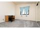 Bedroom with neutral walls, gray carpet, window with blue curtains, and small desk at 2822 La Palma Dr, Laughlin, NV 89029