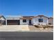 Charming single-story home with white stucco exterior, brown garage door, and desert landscaping at 2822 La Palma Dr, Laughlin, NV 89029