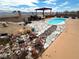 A backyard pool features rock landscaping and an overhead wood structure on a sunny day at 2822 La Palma Dr, Laughlin, NV 89029
