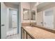 Bathroom featuring granite counters, wood cabinets, and a decorative mirror with bright tile flooring outside at 285 Canyon Spirit Dr, Henderson, NV 89012