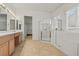 Bright bathroom with double vanity, tiled floors, and a walk-in shower with separate bathtub at 2868 Foxtail Creek Ave, Henderson, NV 89052