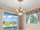 Dining room with chandelier, drapery, and sliding doors to backyard at 2868 Foxtail Creek Ave, Henderson, NV 89052