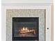 Close-up of the cozy fireplace with stone surround and burning logs at 2868 Foxtail Creek Ave, Henderson, NV 89052