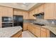 Bright kitchen with granite countertops, stainless-steel appliances, and wood cabinetry at 2868 Foxtail Creek Ave, Henderson, NV 89052
