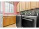 Well-lit laundry room with modern washer and dryer, and ample cabinet storage at 2868 Foxtail Creek Ave, Henderson, NV 89052