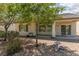 Backyard showcasing mature trees, desert landscaping, and a covered patio with access to the home's interior at 3312 Lapwing Dr, North Las Vegas, NV 89084