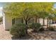 Backyard view featuring a covered patio, low-maintenance gravel landscaping, mature trees and shrubs at 3312 Lapwing Dr, North Las Vegas, NV 89084