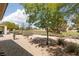Backyard with gravel landscape featuring lush trees and shrubs and an open view of the community golf course at 3312 Lapwing Dr, North Las Vegas, NV 89084