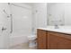 Clean bathroom with a shower and tub combination, a toilet and vanity with wood-look cabinet, and tile flooring at 3312 Lapwing Dr, North Las Vegas, NV 89084