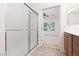 Bathroom featuring a frosted glass shower, tile flooring, wood cabinets and an open view into an adjacent bedroom at 3312 Lapwing Dr, North Las Vegas, NV 89084