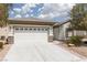 Attractive home with desert landscaping, a concrete driveway, and a bright white garage door at 3312 Lapwing Dr, North Las Vegas, NV 89084