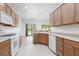 Well-lit kitchen with white appliances, wood cabinetry, and tile floors, ideal for preparing gourmet meals and treats at 3312 Lapwing Dr, North Las Vegas, NV 89084