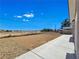 View of the vast backyard featuring low-maintenance landscaping and a spacious concrete patio at 3326 Mount Charleston Dr, Pahrump, NV 89048