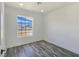 A simple bedroom with hardwood flooring, white walls, base trim, a double-hung window, and recessed lighting at 3326 Mount Charleston Dr, Pahrump, NV 89048