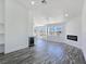 Bright living room with gray wood-look floors, built-in shelving, wine fridge, and an electric fireplace at 3326 Mount Charleston Dr, Pahrump, NV 89048