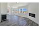 Open-concept living space with gray floors, a sleek electric fireplace, wine cooler, and tons of natural light at 3326 Mount Charleston Dr, Pahrump, NV 89048