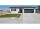 Charming single-story home featuring desert landscaping and a modern garage door at 3440 Ernest St, North Las Vegas, NV 89032