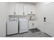 Well-lit laundry room features modern appliances and stylish patterned tile flooring at 3440 Ernest St, North Las Vegas, NV 89032