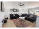 Open-concept living room with plank flooring, two dark sofas and large windows at 3440 Ernest St, North Las Vegas, NV 89032