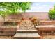 Landscaped backyard with planters, rock features, and block wall at 3619 Hat Rock Ct, Las Vegas, NV 89129