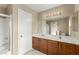 Primary bathroom featuring double sinks with wooden cabinets and a shower at 3619 Hat Rock Ct, Las Vegas, NV 89129