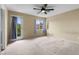 Large, carpeted bedroom featuring ceiling fan, windows, and door to balcony at 3619 Hat Rock Ct, Las Vegas, NV 89129