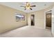 This bedroom includes a ceiling fan, window, and access to bathroom at 3619 Hat Rock Ct, Las Vegas, NV 89129