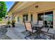 Inviting covered back patio featuring an outdoor dining set and beautifully landscaped surroundings at 3712 Rocklin Peak Ave, North Las Vegas, NV 89081