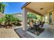 A covered back patio with a table and seating with a view of the meticulously landscaped yard at 3712 Rocklin Peak Ave, North Las Vegas, NV 89081