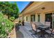 Cozy covered back patio with an outdoor dining set and vibrant landscaping creating a tranquil retreat at 3712 Rocklin Peak Ave, North Las Vegas, NV 89081