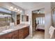 Bathroom featuring double sinks, granite countertop, walk-in shower, leading to bedroom at 3712 Rocklin Peak Ave, North Las Vegas, NV 89081