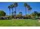Community entrance featuring manicured lawns, tall palm trees, and an American flag at 3712 Rocklin Peak Ave, North Las Vegas, NV 89081