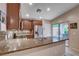 Granite counters, stainless appliances, tile backsplash, and outdoor access enhance this kitchen at 3712 Rocklin Peak Ave, North Las Vegas, NV 89081