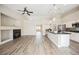 Bright living room with a fireplace, wood-look tile floors, and an open layout to the kitchen at 3882 Genoa Dr, Las Vegas, NV 89141