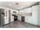 Well-lit kitchen featuring white cabinets, stainless steel appliances, and luxury vinyl plank flooring at 4321 Stockbridge St, Las Vegas, NV 89115