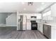 Bright kitchen featuring stainless steel appliances, modern countertops, white cabinets, and luxury vinyl plank flooring at 4321 Stockbridge St, Las Vegas, NV 89115