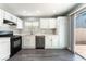 Bright kitchen with white cabinets, stainless steel appliances, and sliding door access to backyard at 4321 Stockbridge St, Las Vegas, NV 89115