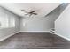 Living room with luxury vinyl plank flooring, light gray walls, large windows, and a modern ceiling fan at 4321 Stockbridge St, Las Vegas, NV 89115