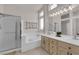 Bright bathroom featuring double sinks, a large mirror, a tub, and a shower at 439 Pelican Bay Ct, Henderson, NV 89012