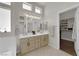 Bright bathroom featuring double sinks, a large mirror, and a walk-in closet at 439 Pelican Bay Ct, Henderson, NV 89012