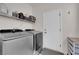 Efficient laundry room with modern washer and dryer, and ample shelving for storage at 439 Pelican Bay Ct, Henderson, NV 89012