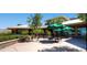 Outdoor patio with tables, chairs, and umbrellas surrounded by lush greenery, offering a relaxing atmosphere at 439 Pelican Bay Ct, Henderson, NV 89012